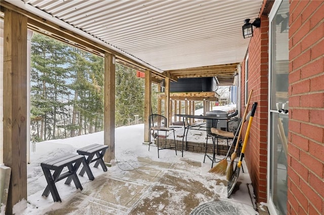 snow covered patio featuring a grill