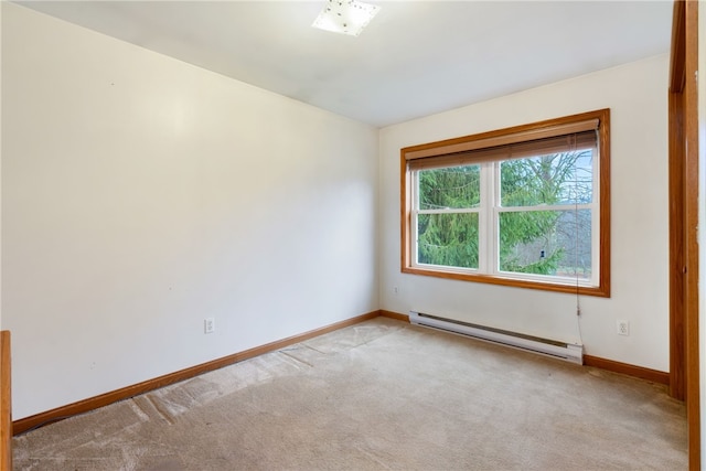 spare room featuring a baseboard radiator and light colored carpet