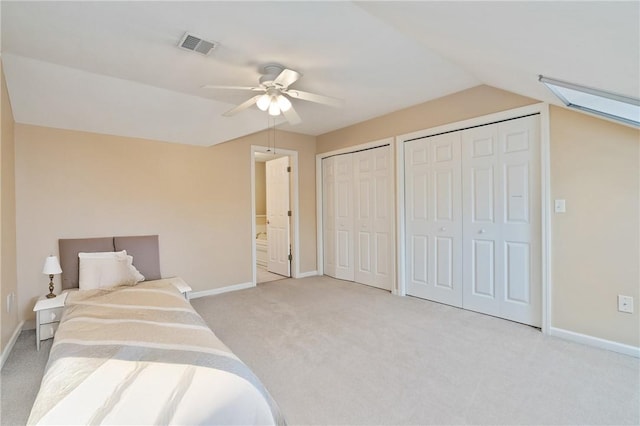 carpeted bedroom with multiple closets, ceiling fan, and lofted ceiling