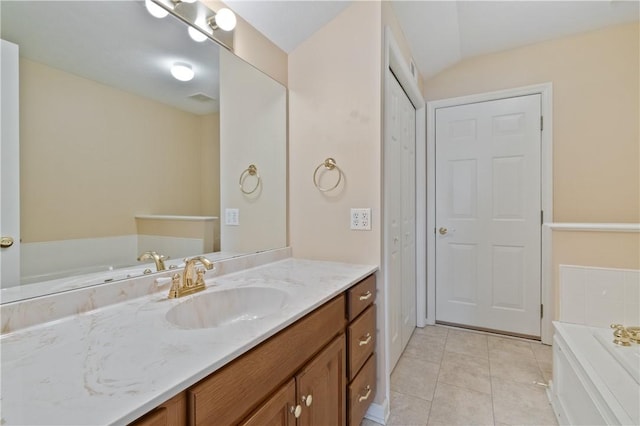 bathroom with a washtub, tile patterned floors, vanity, and vaulted ceiling