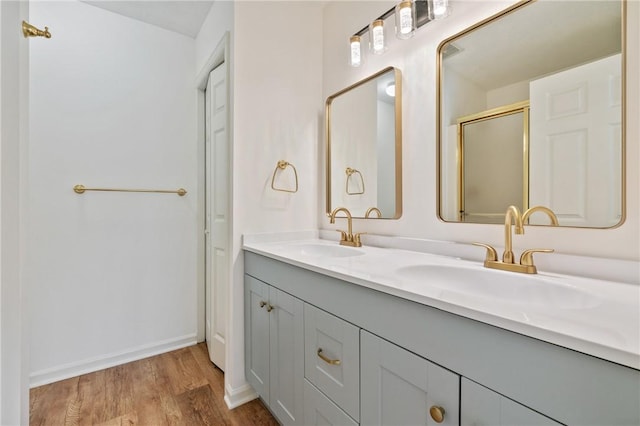 bathroom featuring hardwood / wood-style flooring, vanity, and a shower with door