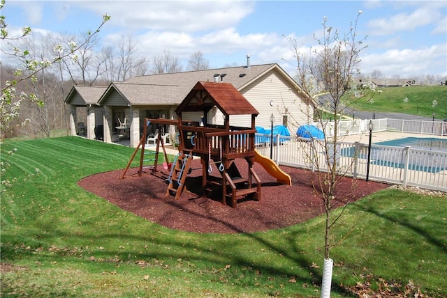 view of jungle gym with a covered pool and a yard