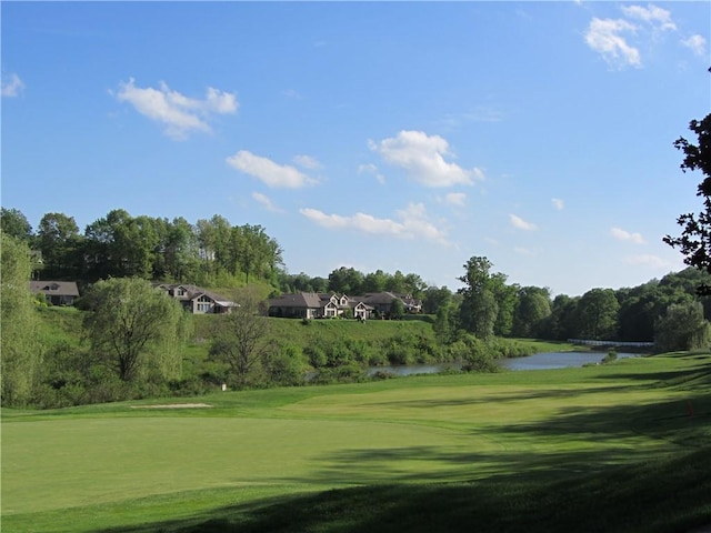 surrounding community with a water view and a yard