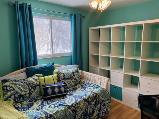 bedroom with multiple windows and hardwood / wood-style floors