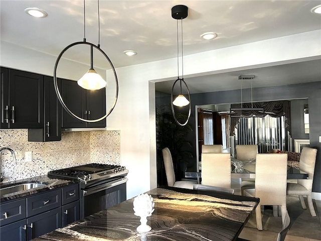 kitchen with decorative backsplash, sink, decorative light fixtures, and stainless steel gas range oven