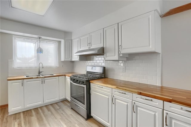 kitchen with sink, wood counters, gas range, and white cabinetry