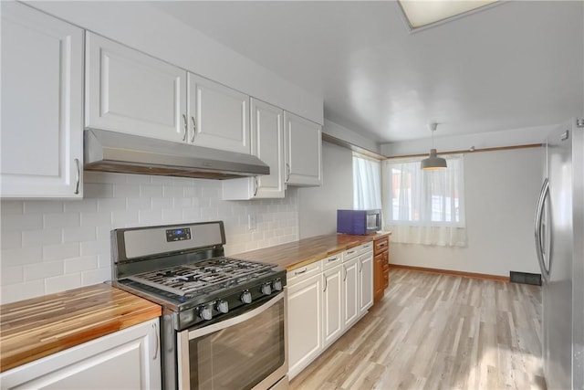 kitchen featuring butcher block counters, tasteful backsplash, hanging light fixtures, white cabinets, and stainless steel appliances