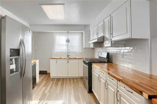 kitchen featuring white cabinets, wood counters, and appliances with stainless steel finishes