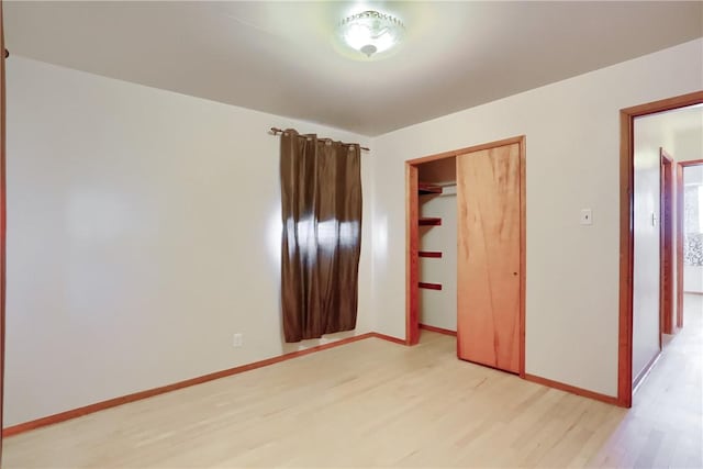 unfurnished bedroom featuring a closet and light hardwood / wood-style floors