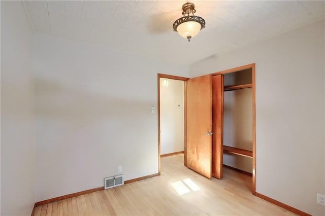 unfurnished bedroom with light hardwood / wood-style floors and a closet