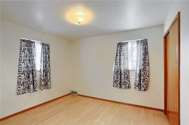 empty room featuring wood-type flooring and a wealth of natural light