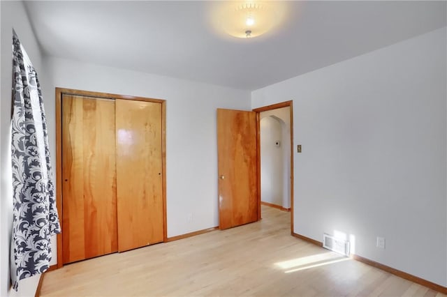 unfurnished bedroom with a closet and light wood-type flooring