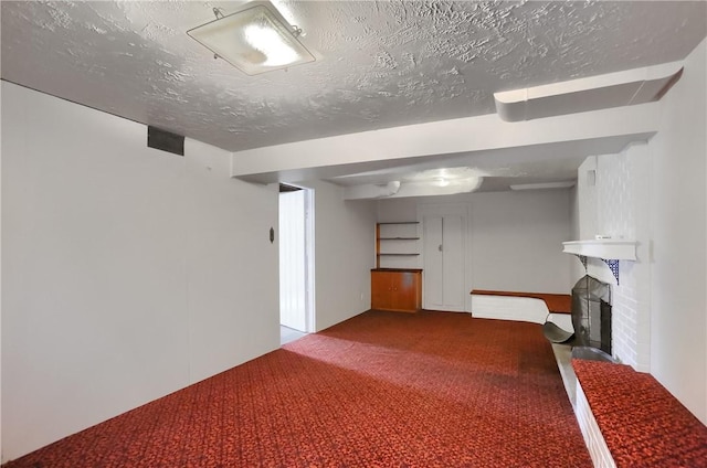 basement featuring carpet flooring, a fireplace, and a textured ceiling