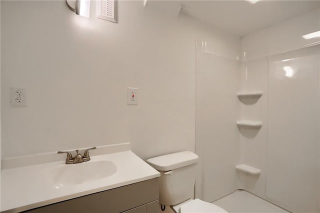 bathroom with toilet, a shower, and vanity