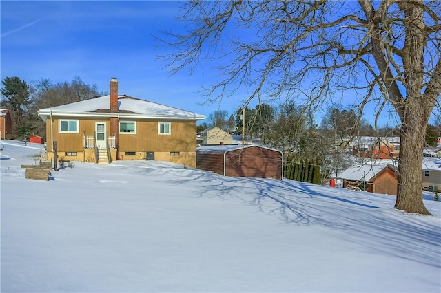 view of snow covered rear of property