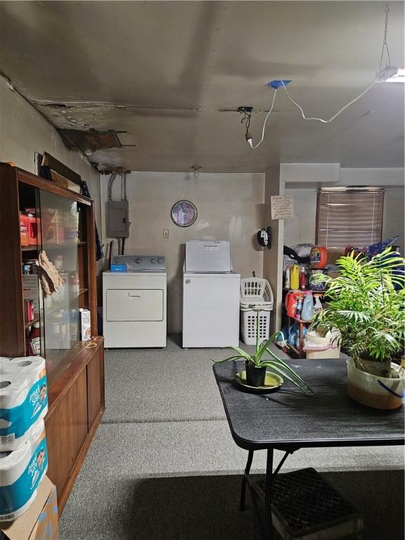 basement with electric panel, white fridge, and washing machine and clothes dryer