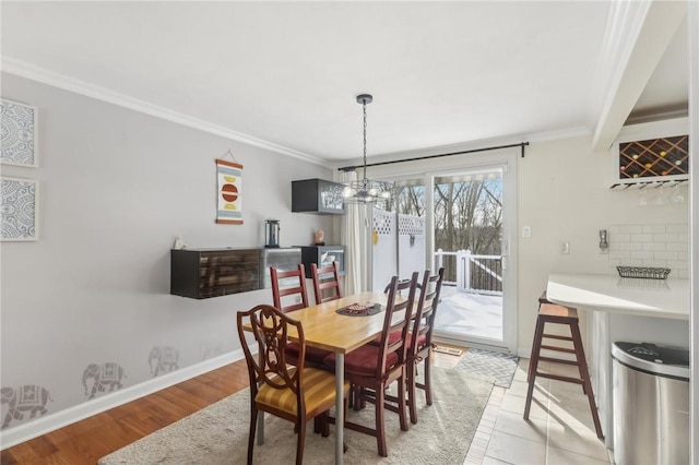 dining space featuring crown molding, a chandelier, and light wood-type flooring