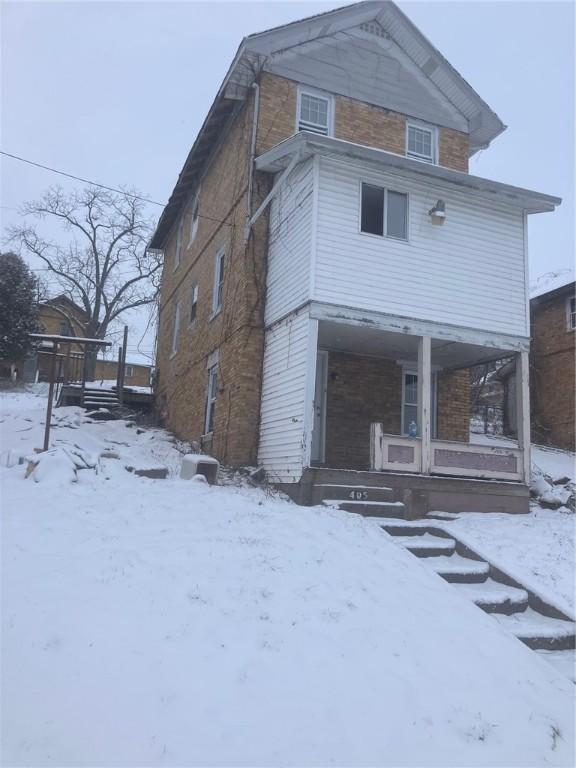 snow covered property featuring a porch