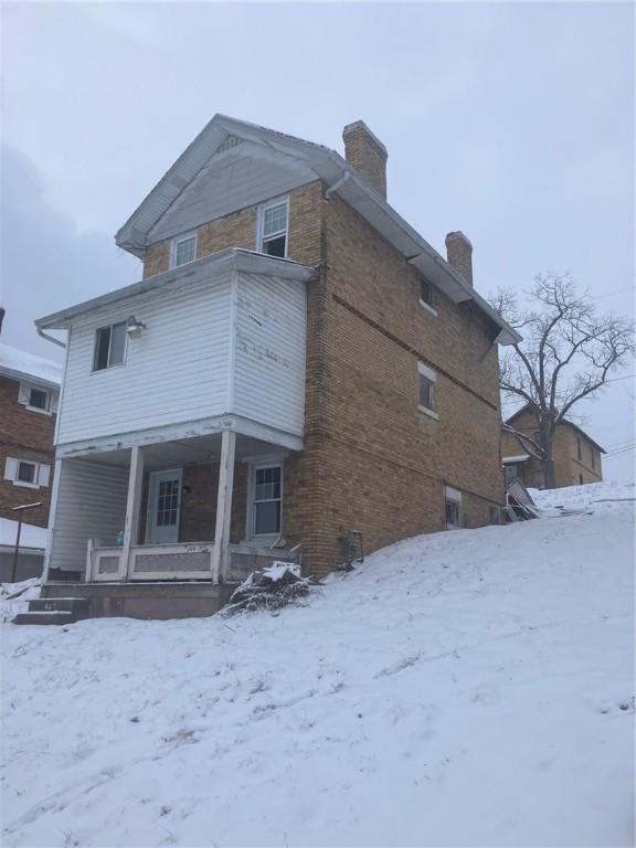 snow covered property featuring covered porch