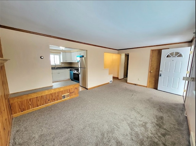 unfurnished living room with crown molding and light carpet