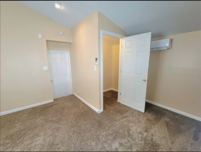 unfurnished bedroom with an AC wall unit, carpet flooring, and vaulted ceiling