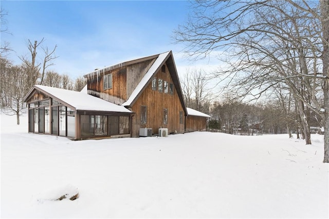 snow covered property featuring central AC unit