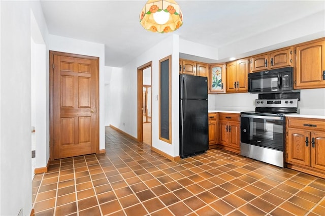 kitchen with black appliances and dark tile patterned flooring