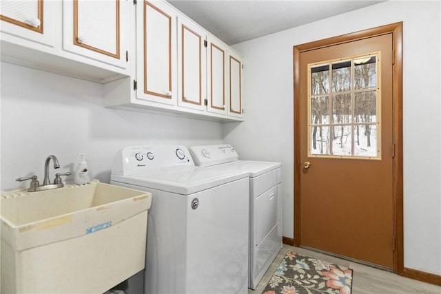 laundry room with sink, separate washer and dryer, cabinets, and light wood-type flooring