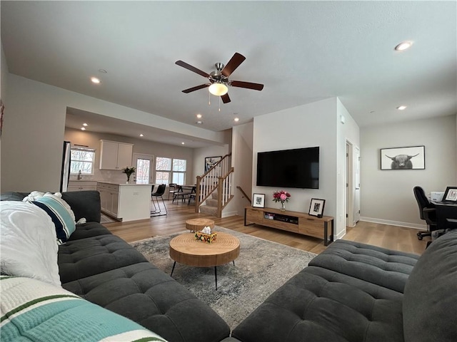 living room featuring ceiling fan and light hardwood / wood-style flooring