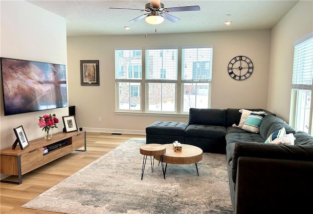 living room with light hardwood / wood-style flooring, ceiling fan, and plenty of natural light