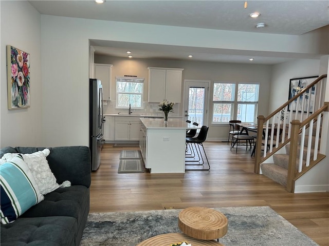 kitchen with hardwood / wood-style floors, stainless steel fridge, and sink