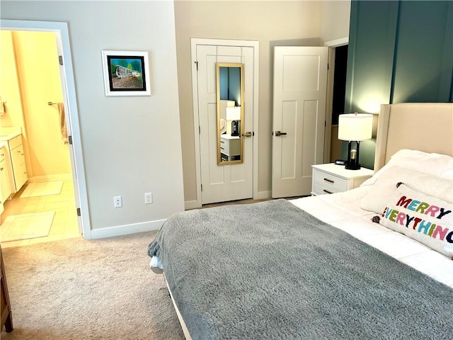 bedroom featuring light carpet and ensuite bath