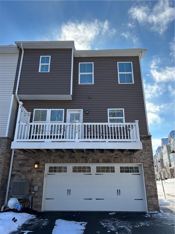 view of front of home featuring a garage and central AC