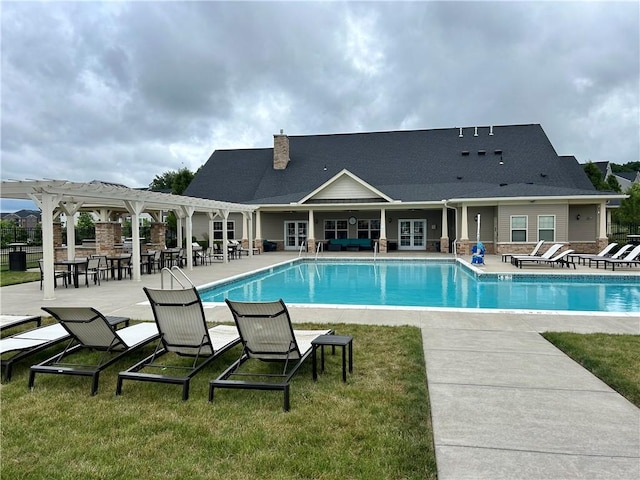 view of pool with a pergola, a patio, and a lawn