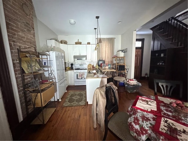 kitchen featuring white appliances, decorative light fixtures, white cabinetry, tasteful backsplash, and dark hardwood / wood-style floors