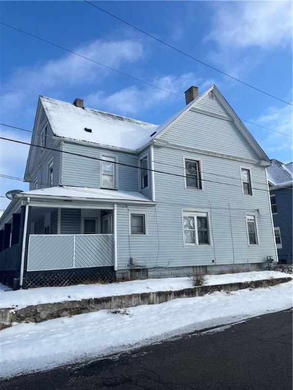 view of snowy exterior featuring covered porch