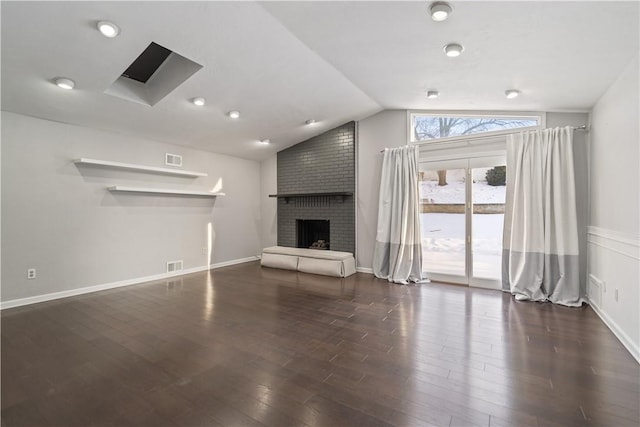 unfurnished living room featuring dark wood-type flooring, lofted ceiling, and a brick fireplace