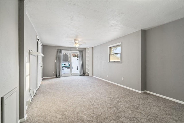 carpeted spare room with ceiling fan