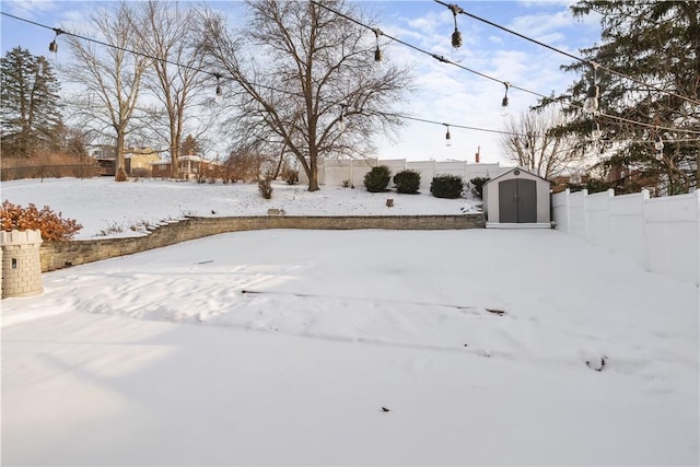 yard covered in snow featuring a storage shed