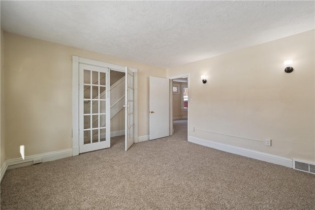 empty room featuring carpet and a textured ceiling