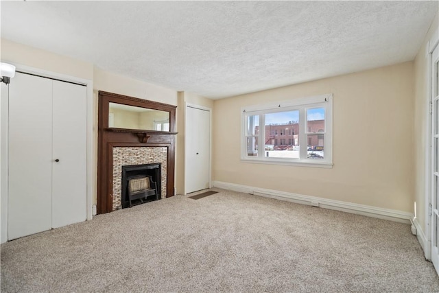 unfurnished living room with a fireplace, carpet flooring, and a textured ceiling