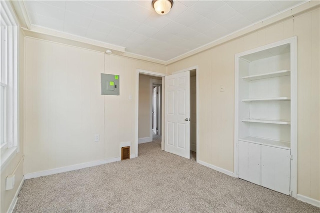 unfurnished bedroom with carpet floors, electric panel, and crown molding