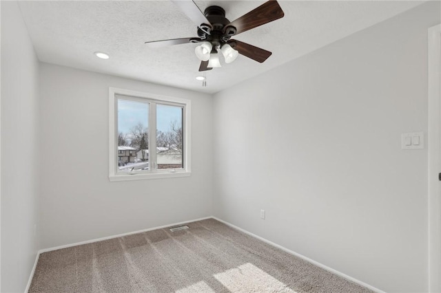 spare room with ceiling fan, a textured ceiling, and carpet floors