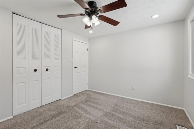 unfurnished bedroom with ceiling fan, carpet, and a closet