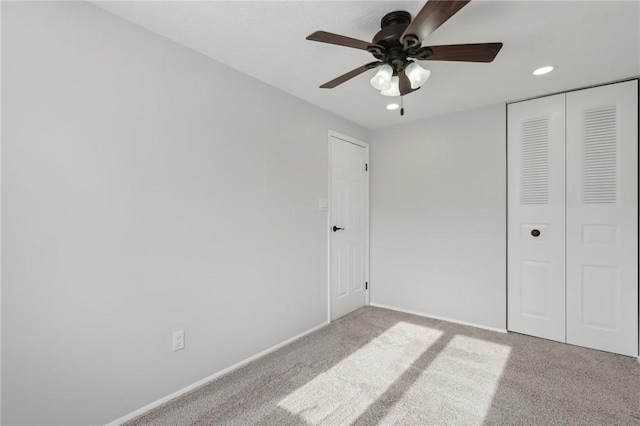 unfurnished bedroom with light colored carpet, a closet, and ceiling fan