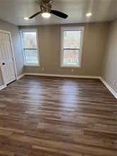 unfurnished bedroom with ceiling fan and dark hardwood / wood-style flooring