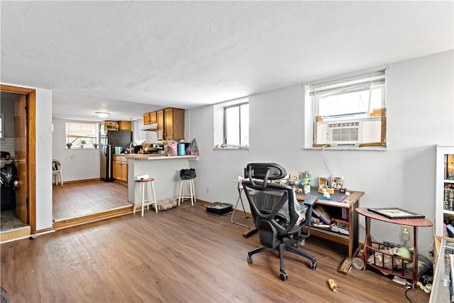 office featuring hardwood / wood-style floors, a textured ceiling, and cooling unit