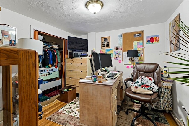 home office featuring hardwood / wood-style floors and a textured ceiling