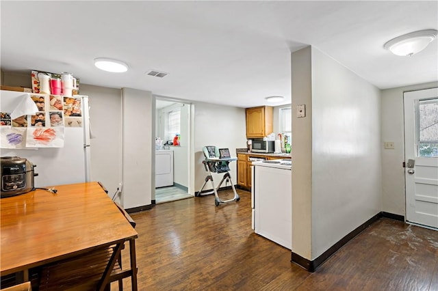 kitchen with washer / clothes dryer, white appliances, and dark wood-type flooring