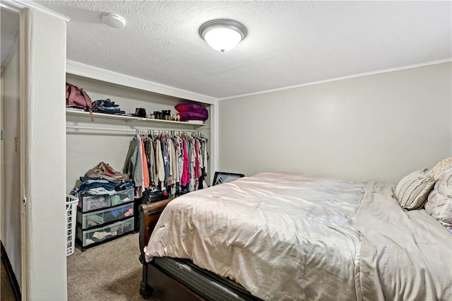 bedroom featuring a closet, a textured ceiling, carpet floors, and crown molding